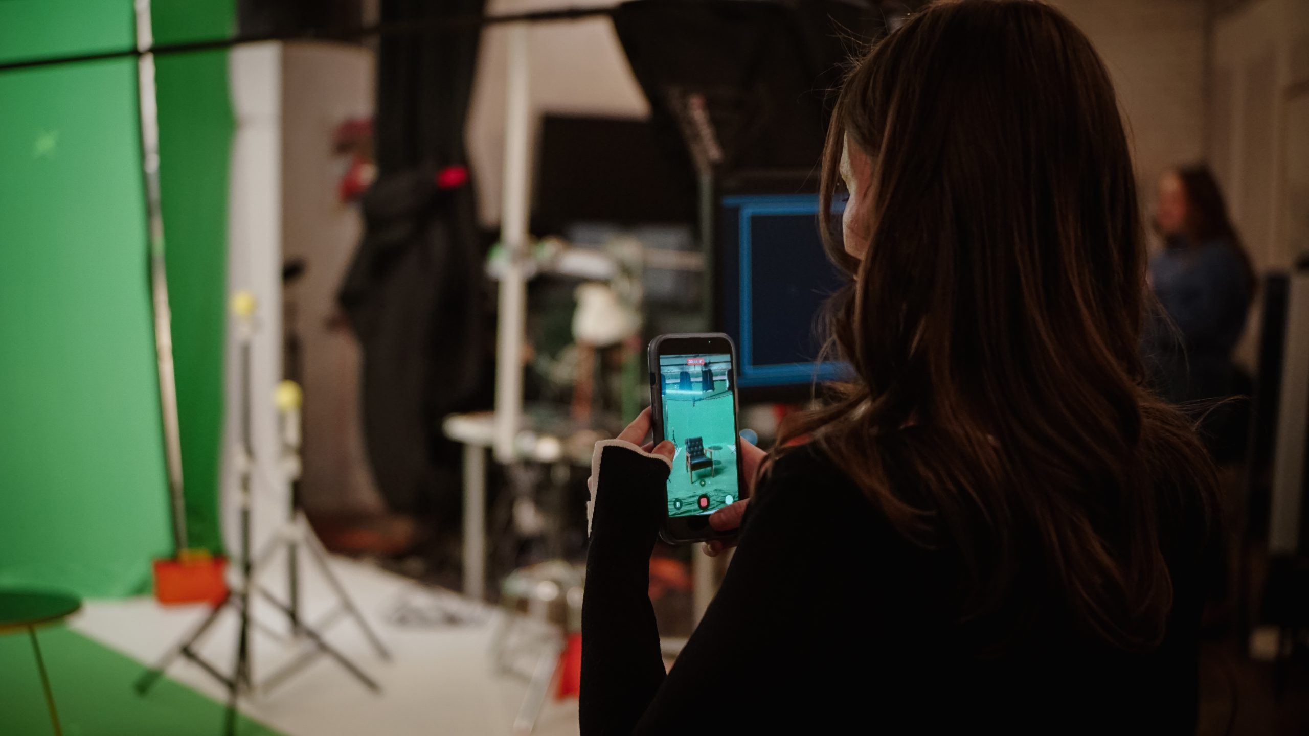 Someone takes a picture using their iPhone, we can see the screen of the phone and the back of their head.